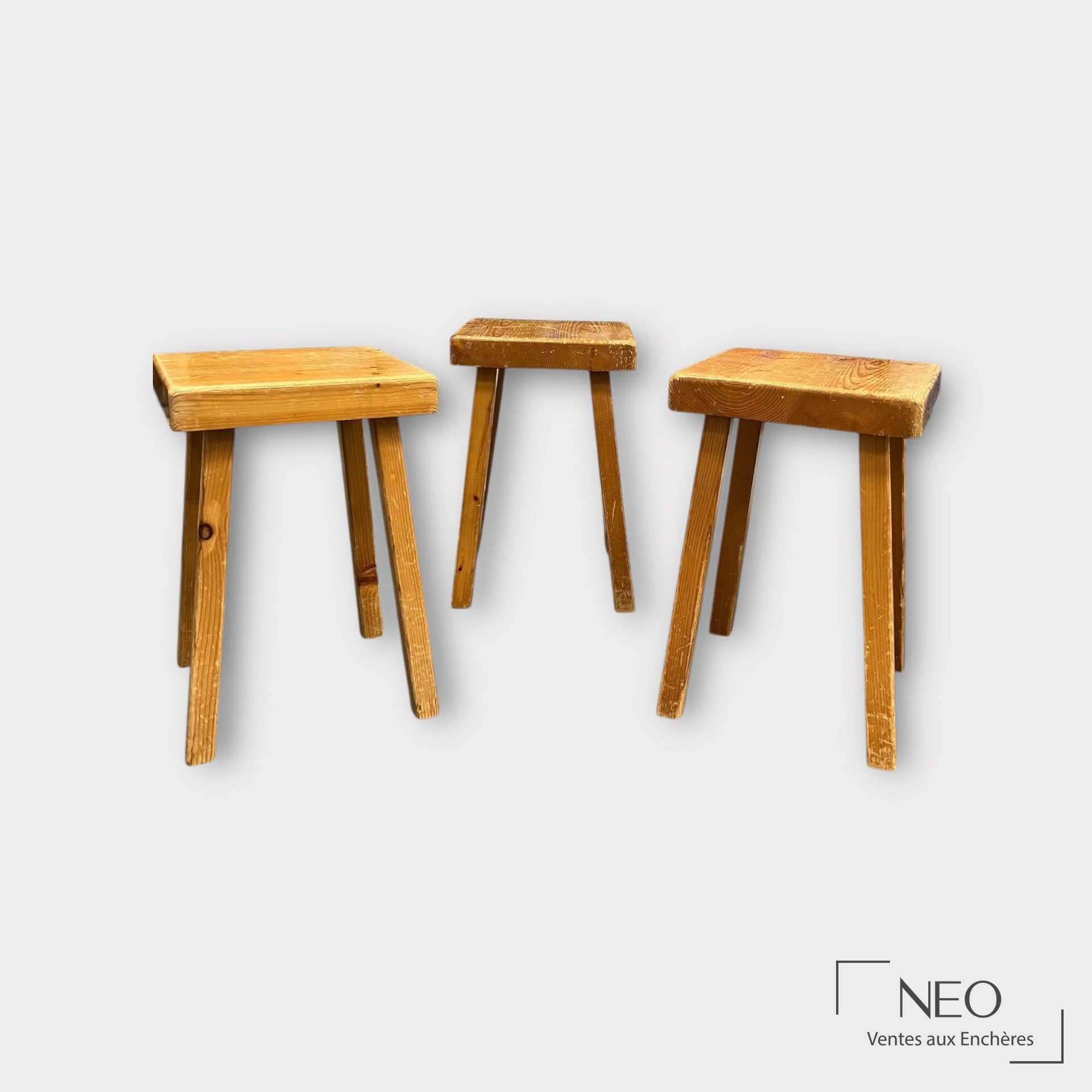 Tabourets en bois vus de l’arrière, avec assises carrées et pieds obliques