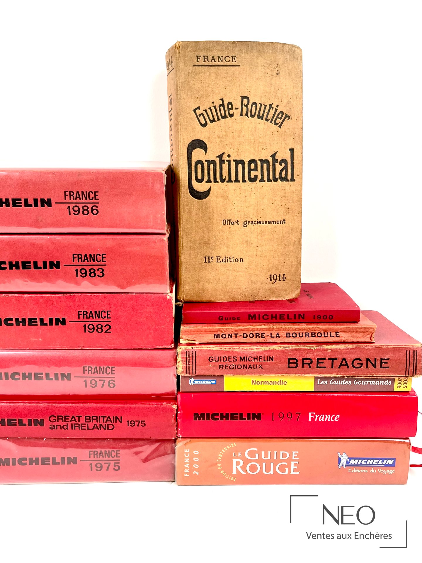 Guide Routier Continental 1914 avec plusieurs guides Michelin en arrière-plan